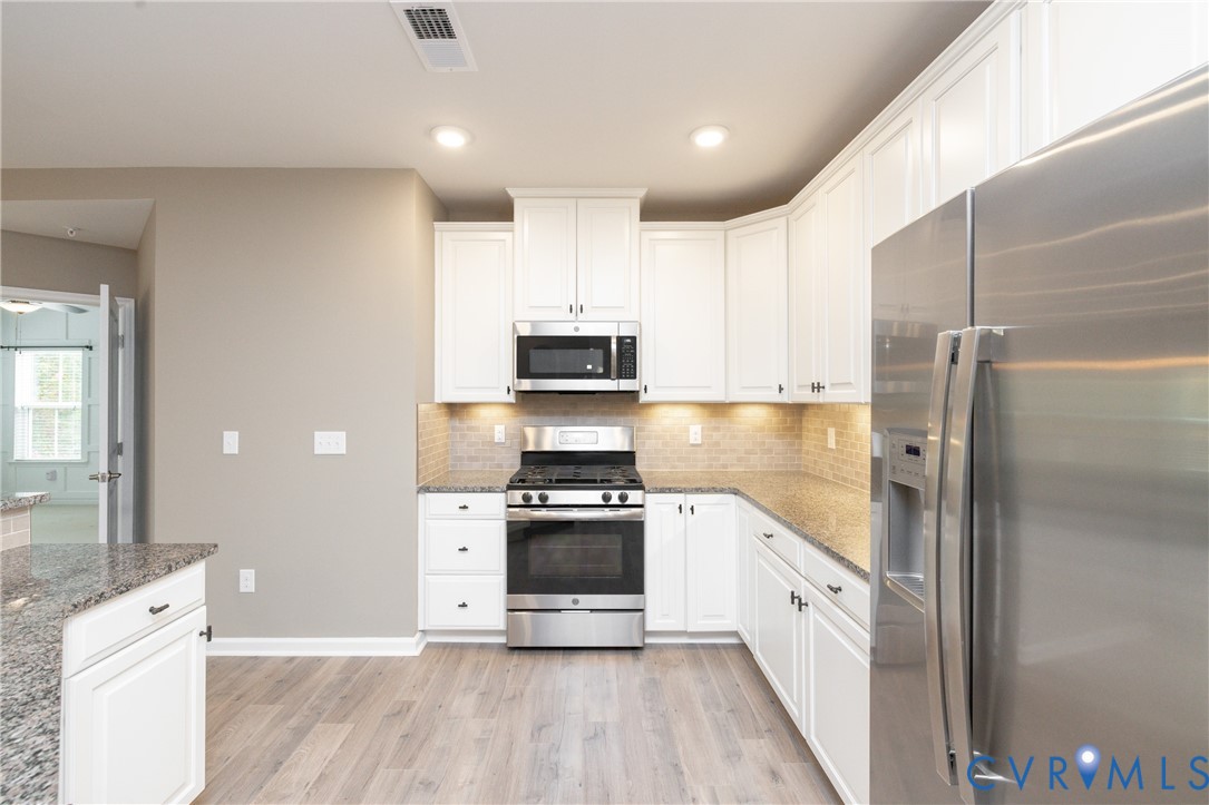 1111 Briars Court, Unit 303 Midlothian, VA 23114 - Photo 8 of 41 a kitchen with stainless steel appliances a stove a sink and a refrigerator