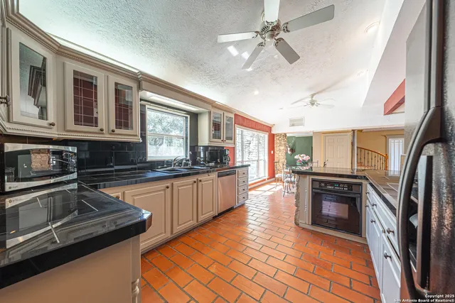a kitchen with stainless steel appliances granite countertop a sink and cabinets