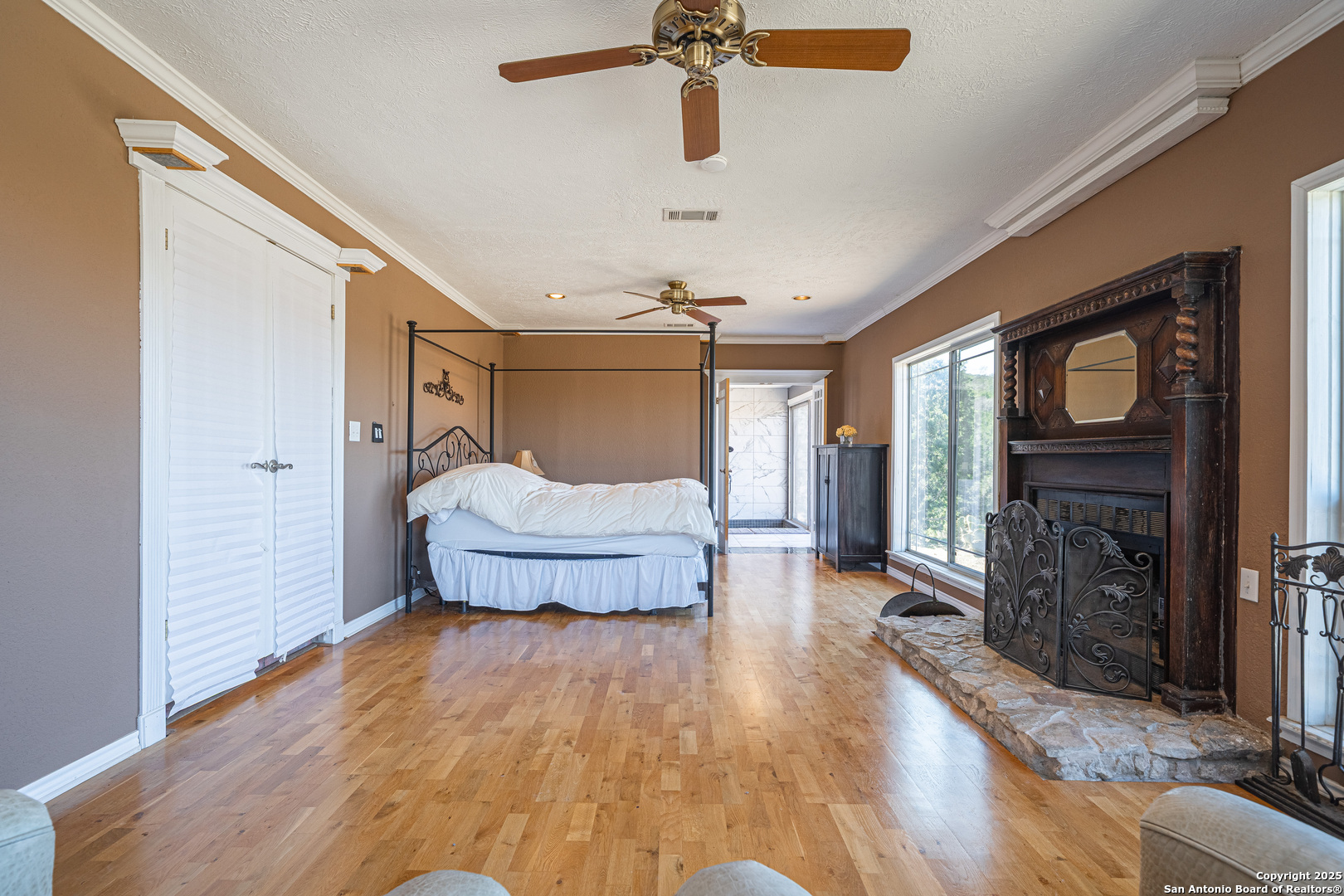 1839 Thanksgiving Road Utopia, TX 78884 - Photo 34 of 96 a spacious bedroom with a bed and a fireplace