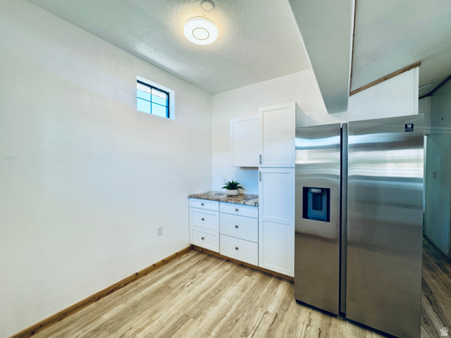 150 North 3050 East, Unit 4 St. George, UT 84790 - Photo 7 of 24 Stainless steel side-by-side refrigerator, white cabinetry, speckled countertop, and wood-finish flooring