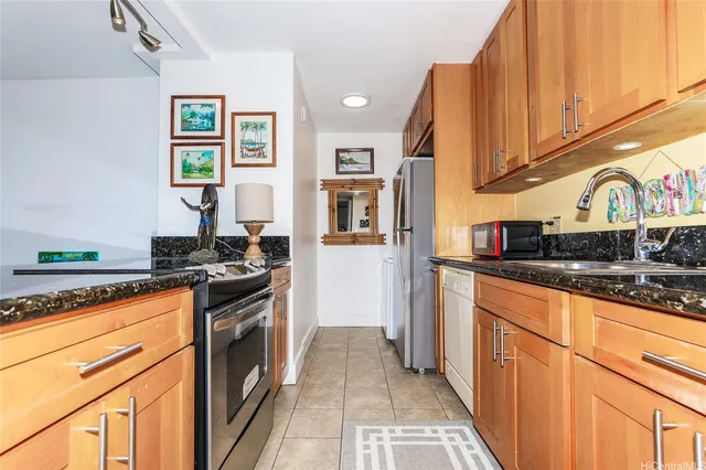 a kitchen with stainless steel appliances granite countertop sink stove top oven and cabinets