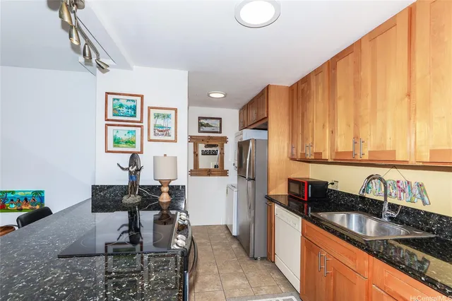 a kitchen with a sink a refrigerator and cabinets