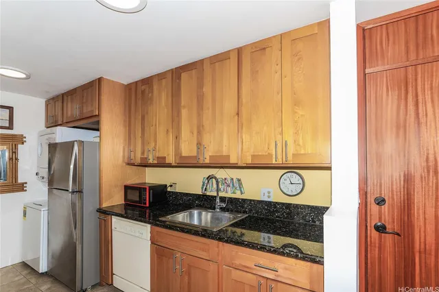 a kitchen with stainless steel appliances kitchen island granite countertop a refrigerator and a stove top oven