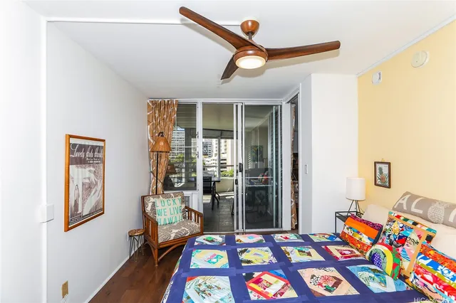 a bedroom with a bed a dresser and a chandelier