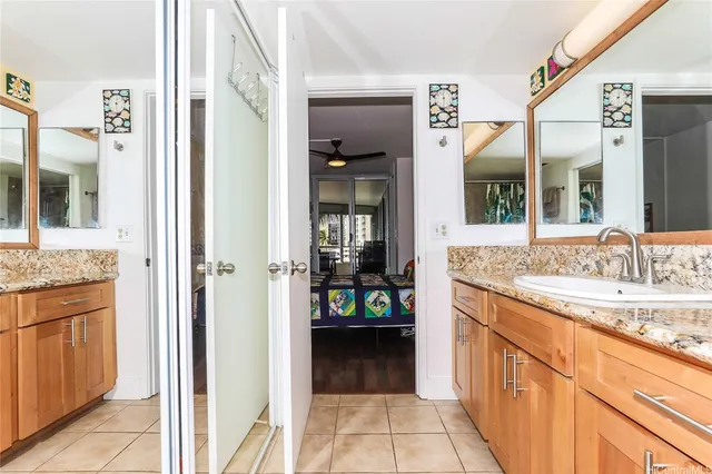 a bathroom with a granite countertop bathtub a sink and a large mirror