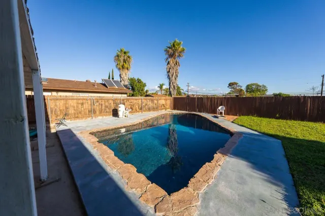 a swimming pool with outdoor seating and a patio