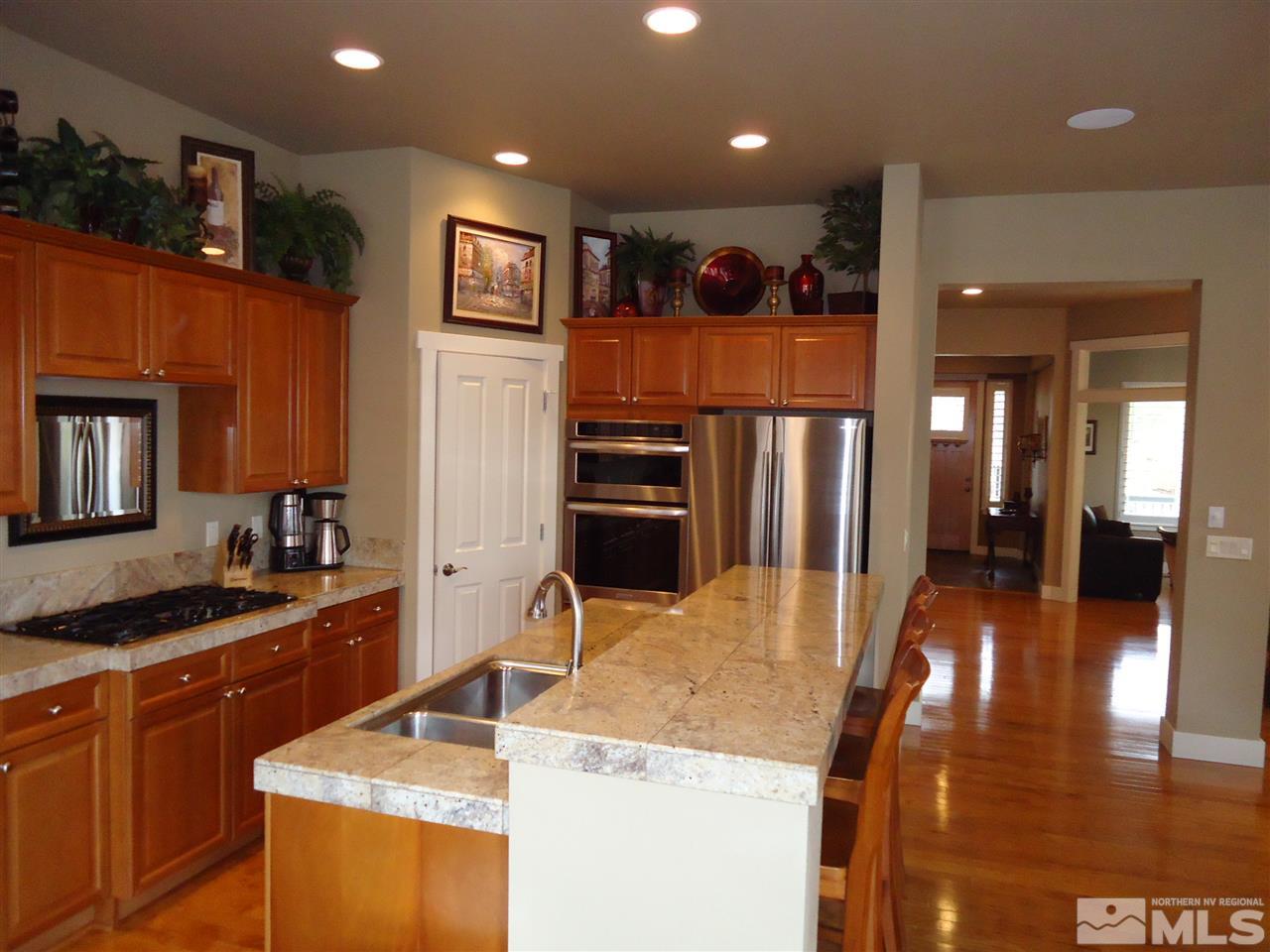 4950 Turning Leaf Way Reno, NV 89519 - Photo 3 of 11 a kitchen with stainless steel appliances granite countertop a sink and a refrigerator