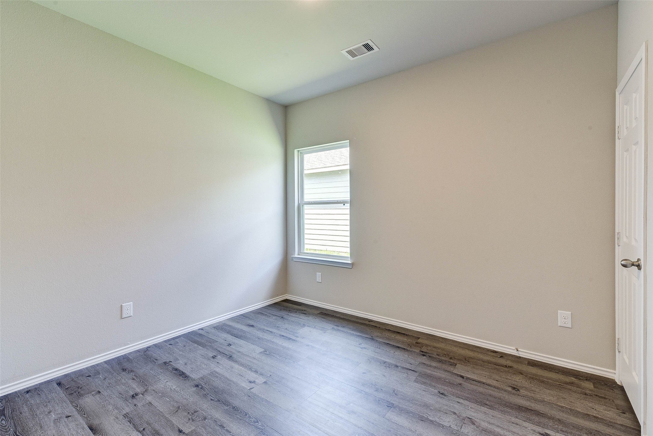 409 East Avenue G Conroe, TX 77301 - Photo 11 of 22 an empty room with wooden floor and windows