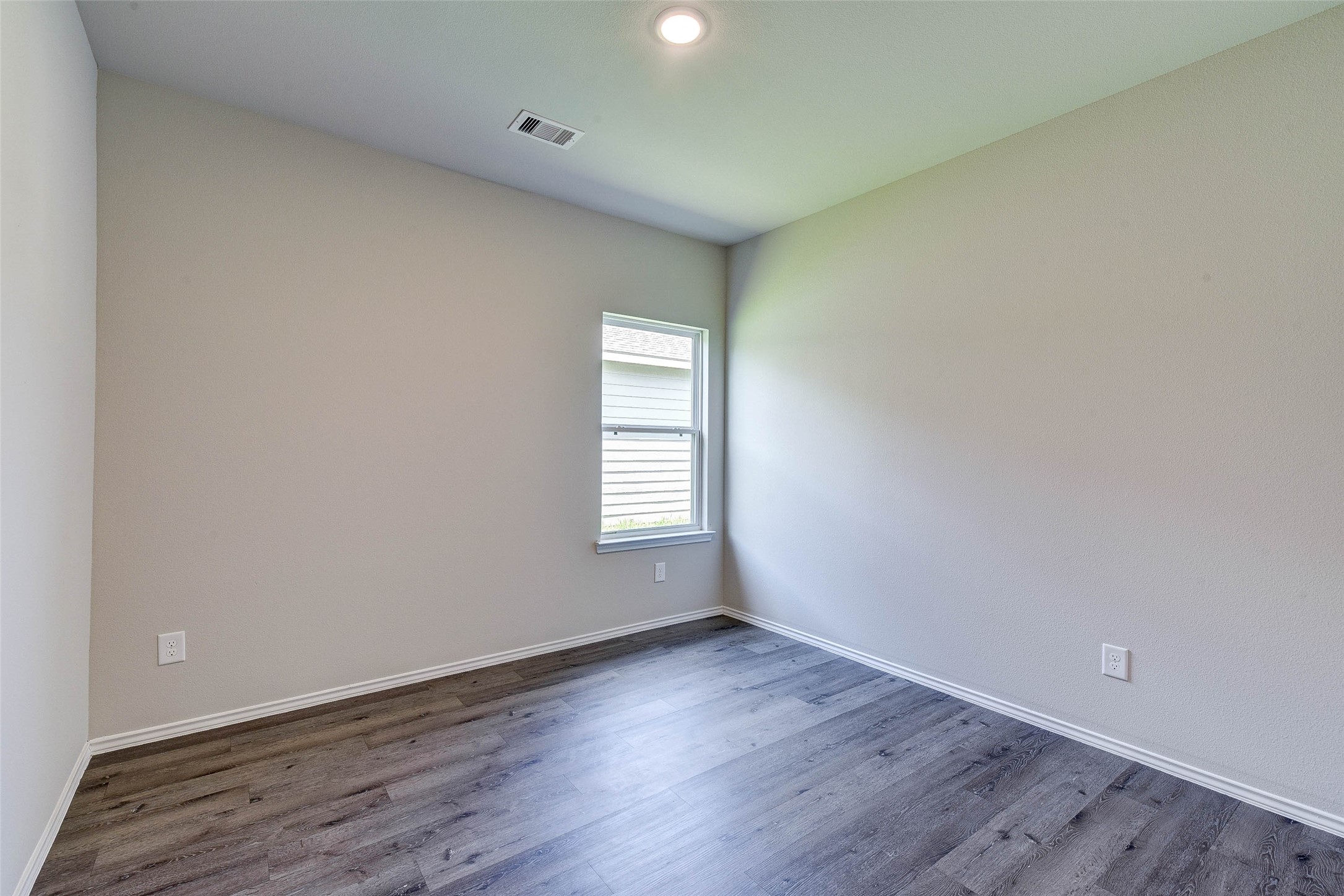 409 East Avenue G Conroe, TX 77301 - Photo 13 of 22 wooden floor in an empty room with a window