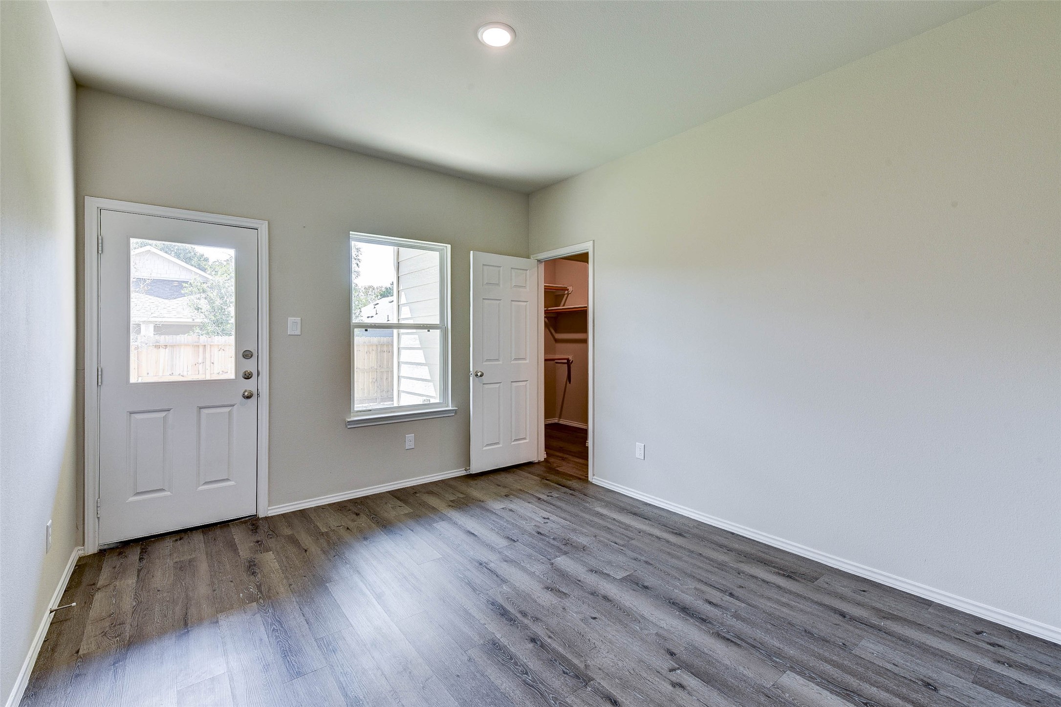 409 East Avenue G Conroe, TX 77301 - Photo 15 of 22 an empty room with wooden floor and windows