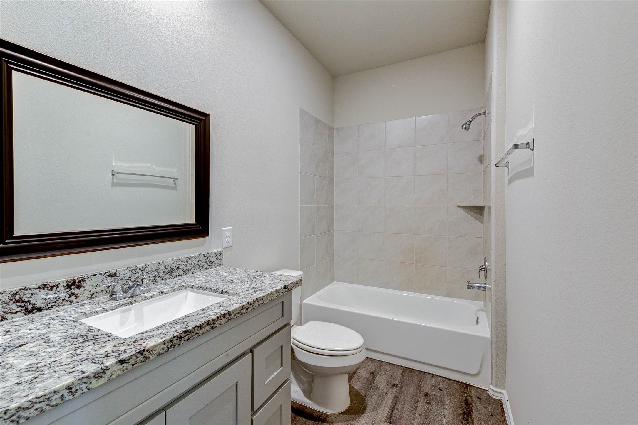 409 East Avenue G Conroe, TX 77301 - Photo 18 of 22 a bathroom with a granite countertop sink toilet and shower