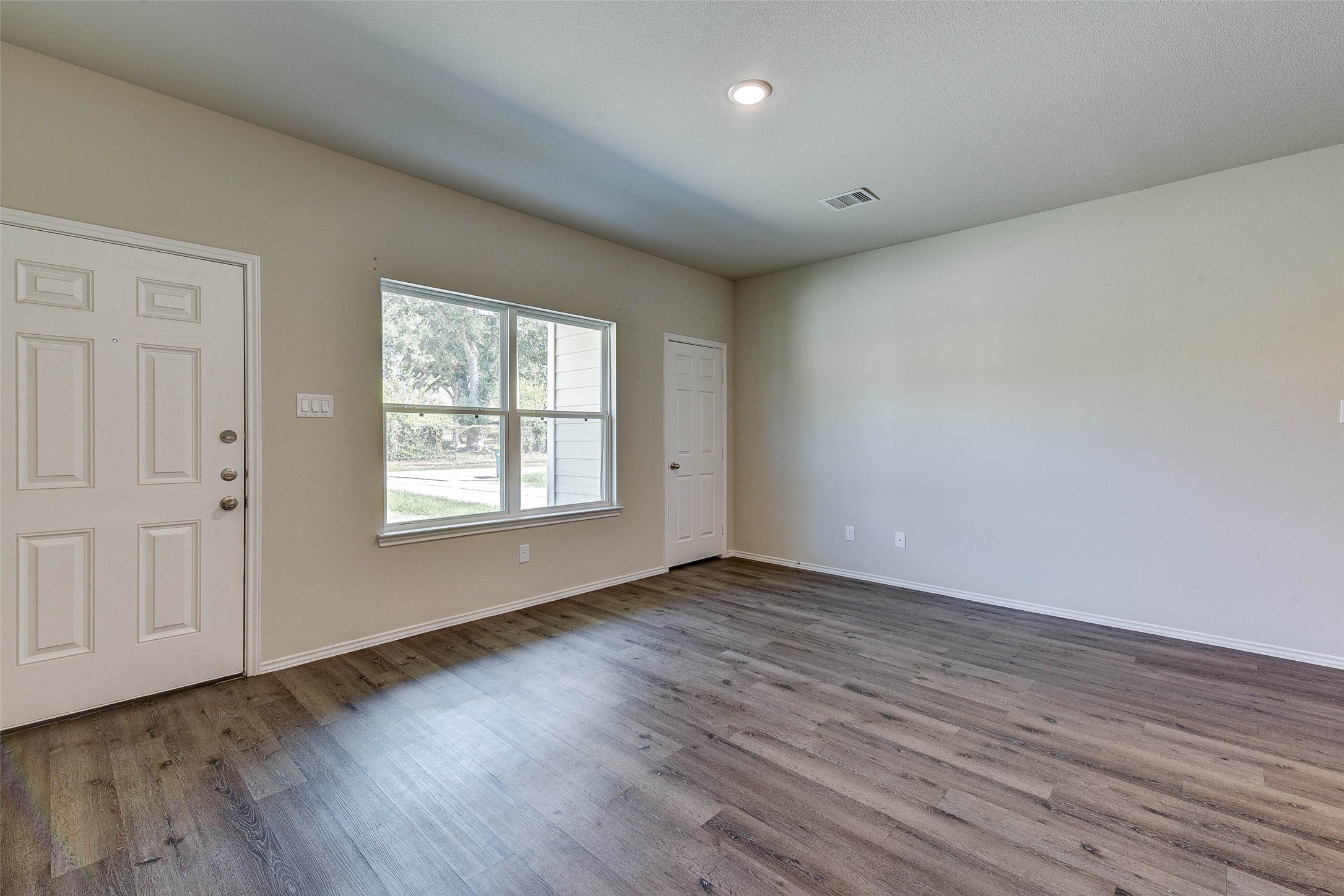 409 East Avenue G Conroe, TX 77301 - Photo 4 of 22 a view of an empty room with wooden floor and a window
