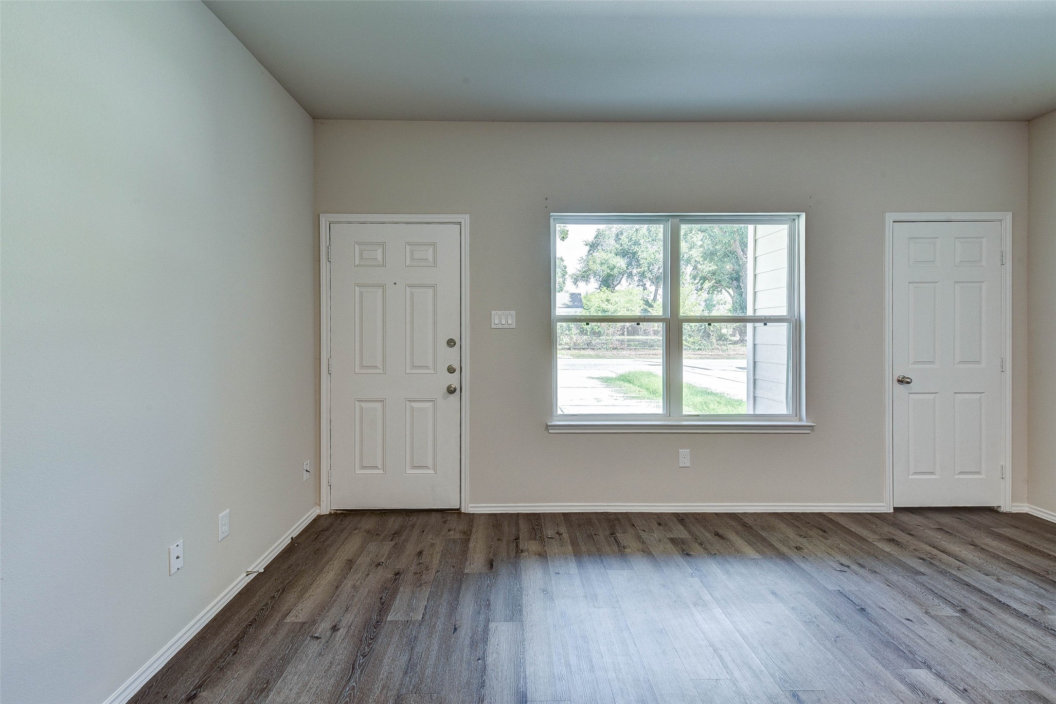409 East Avenue G Conroe, TX 77301 - Photo 5 of 22 an empty room with wooden floor and windows