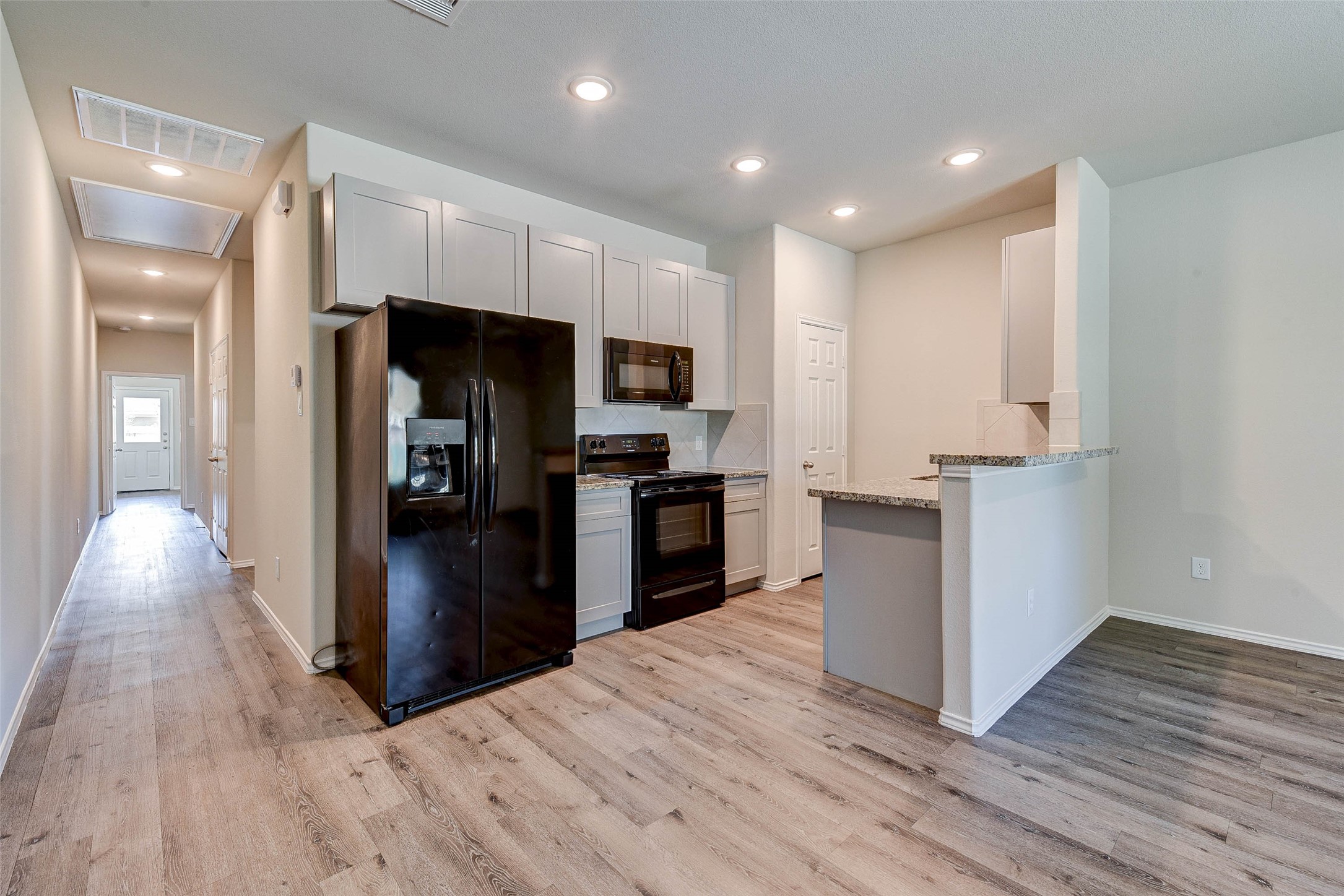 409 East Avenue G Conroe, TX 77301 - Photo 7 of 22 a kitchen with a refrigerator and a stove top oven