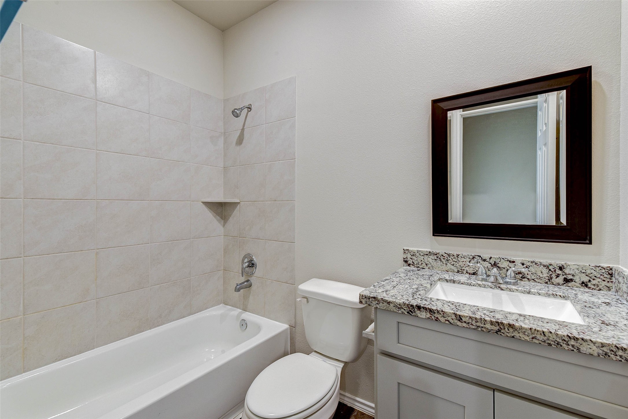 409 East Avenue G Conroe, TX 77301 - Photo 10 of 22 a bathroom with a granite countertop toilet a sink and bathtub