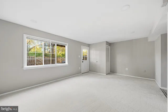 a view of a backyard with wooden fence and large trees