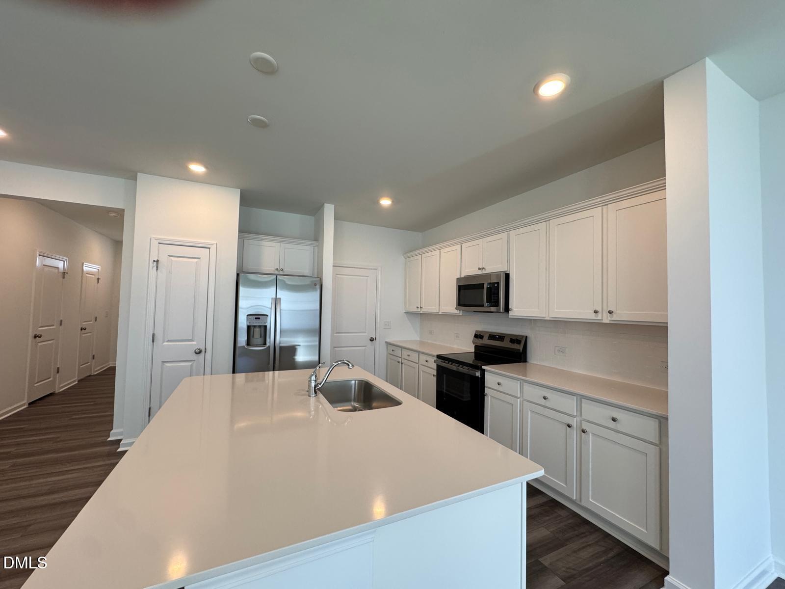 261 Lily Patch Lane Smithfield, NC 27577 - Photo 2 of 15 a kitchen with stainless steel appliances kitchen island sink refrigerator and cabinets