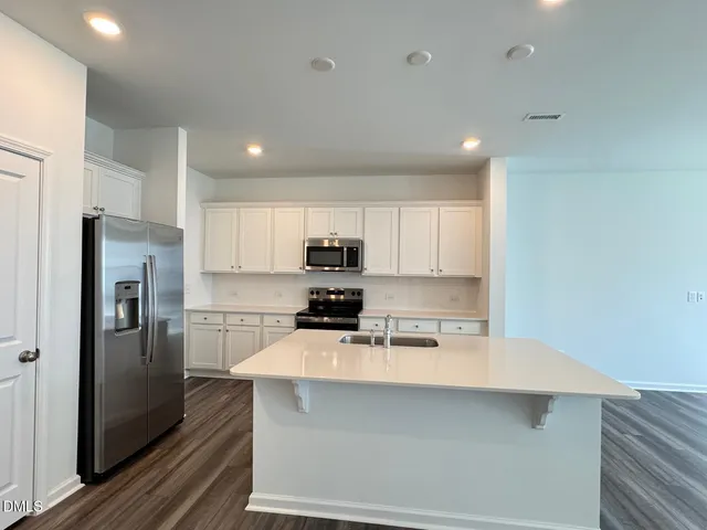 a kitchen with stainless steel appliances a refrigerator sink and stove