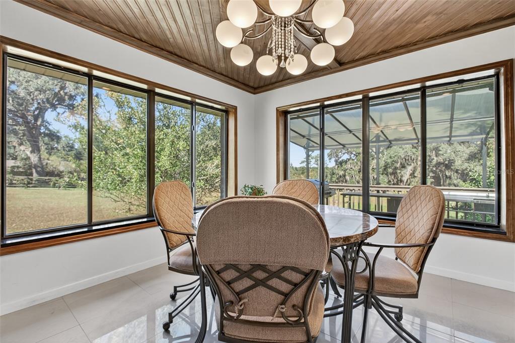 12903 112th Avenue Alachua, FL 32615 - Photo 17 of 95 a view of a dining room with furniture large windows and wooden floor
