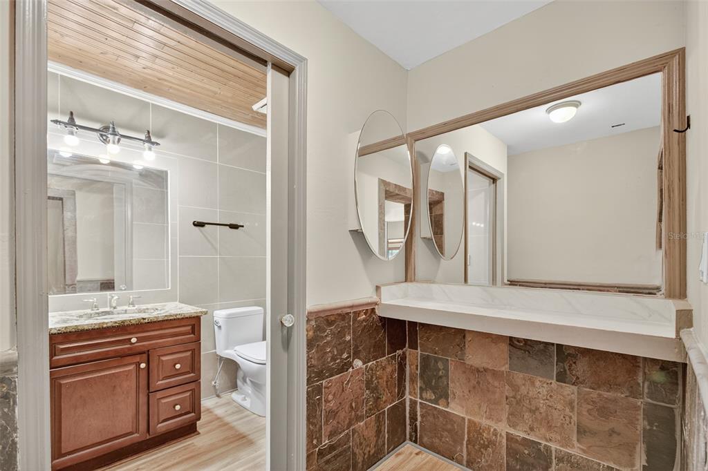 12903 112th Avenue Alachua, FL 32615 - Photo 51 of 95 a bathroom with a granite countertop sink mirror and