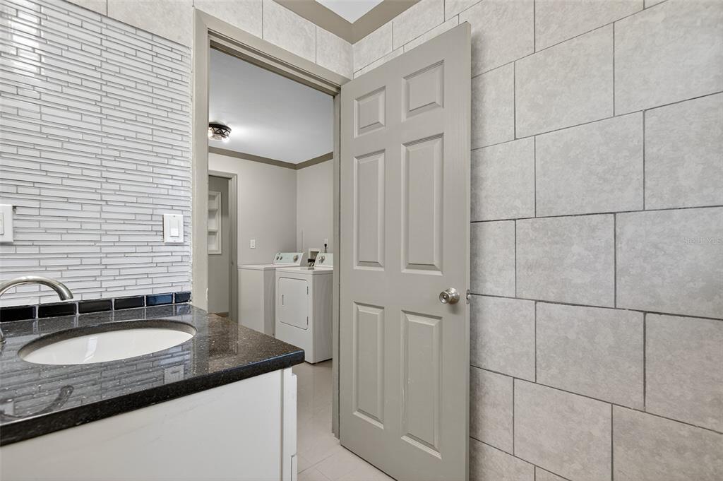12903 112th Avenue Alachua, FL 32615 - Photo 58 of 95 a bathroom with a granite countertop sink and a mirror