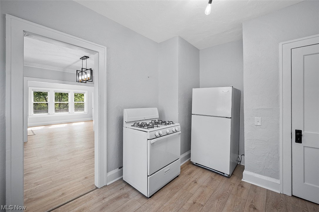 2174 Oakdale Road Cleveland, OH 44118 - Photo 28 of 35 Kitchen with white appliances, a notable chandelier, and light hardwood floors