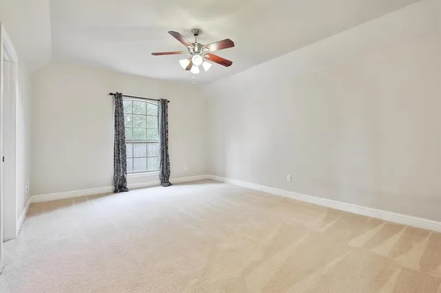 an empty room with chandelier fan