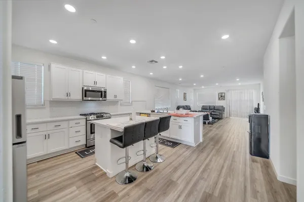a kitchen with stainless steel appliances kitchen island granite countertop a sink and a refrigerator