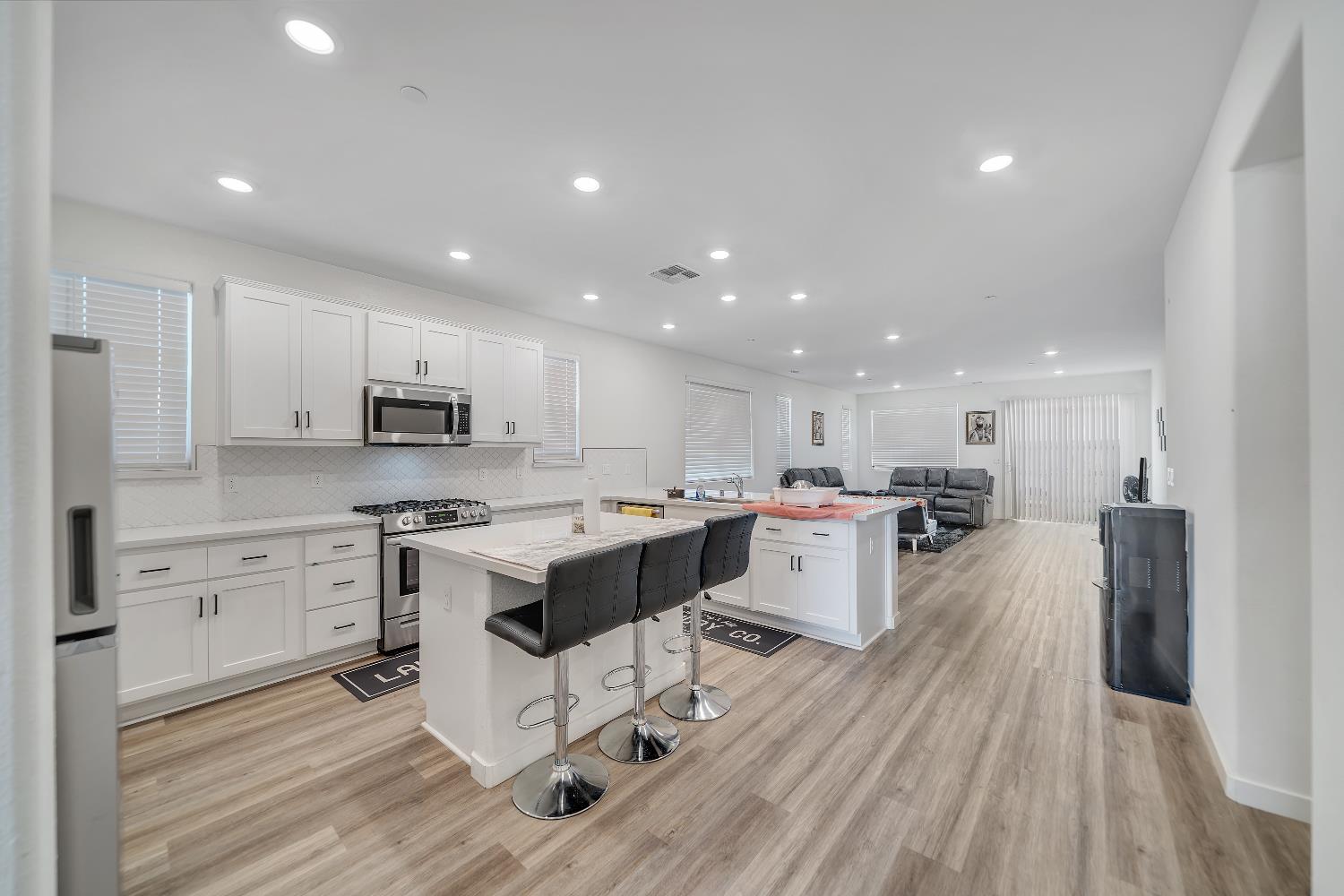 4806 Ariel Street Keyes, CA 95328 - Photo 14 of 42 a large kitchen with stainless steel appliances lots of counter space and wooden floor