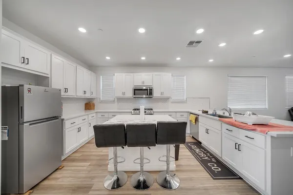 a kitchen with granite countertop white cabinets and stainless steel appliances