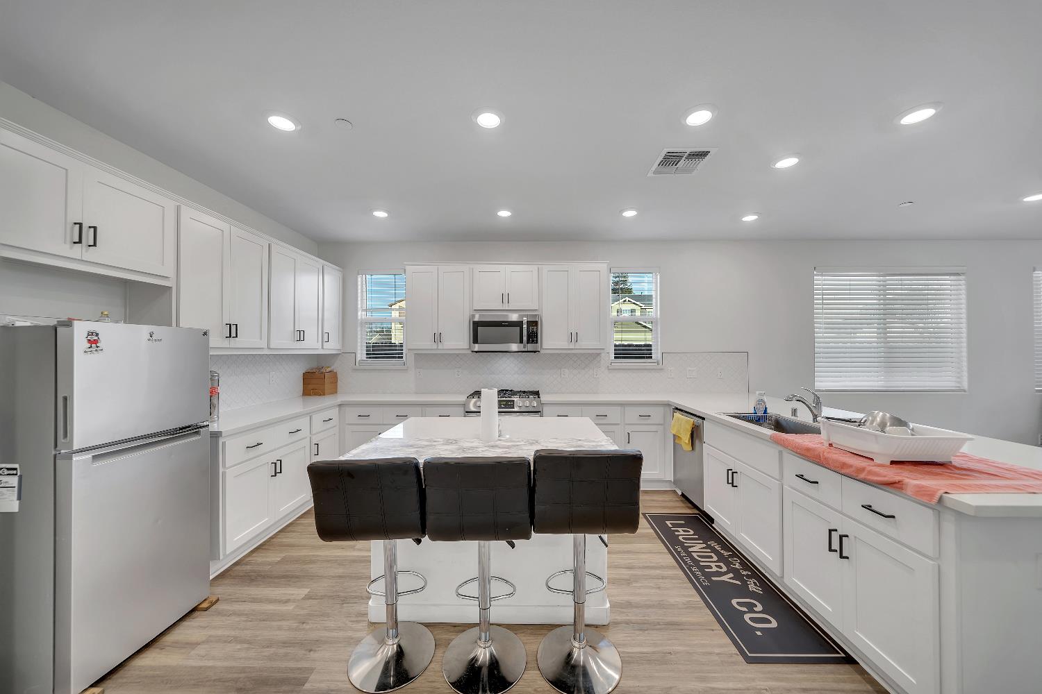 4806 Ariel Street Keyes, CA 95328 - Photo 16 of 42 a kitchen with stainless steel appliances kitchen island granite countertop a sink and a refrigerator