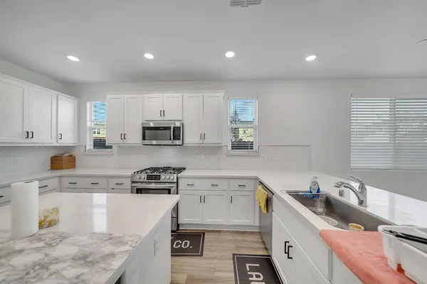 a bathroom with a double vanity sink a toilet and shower