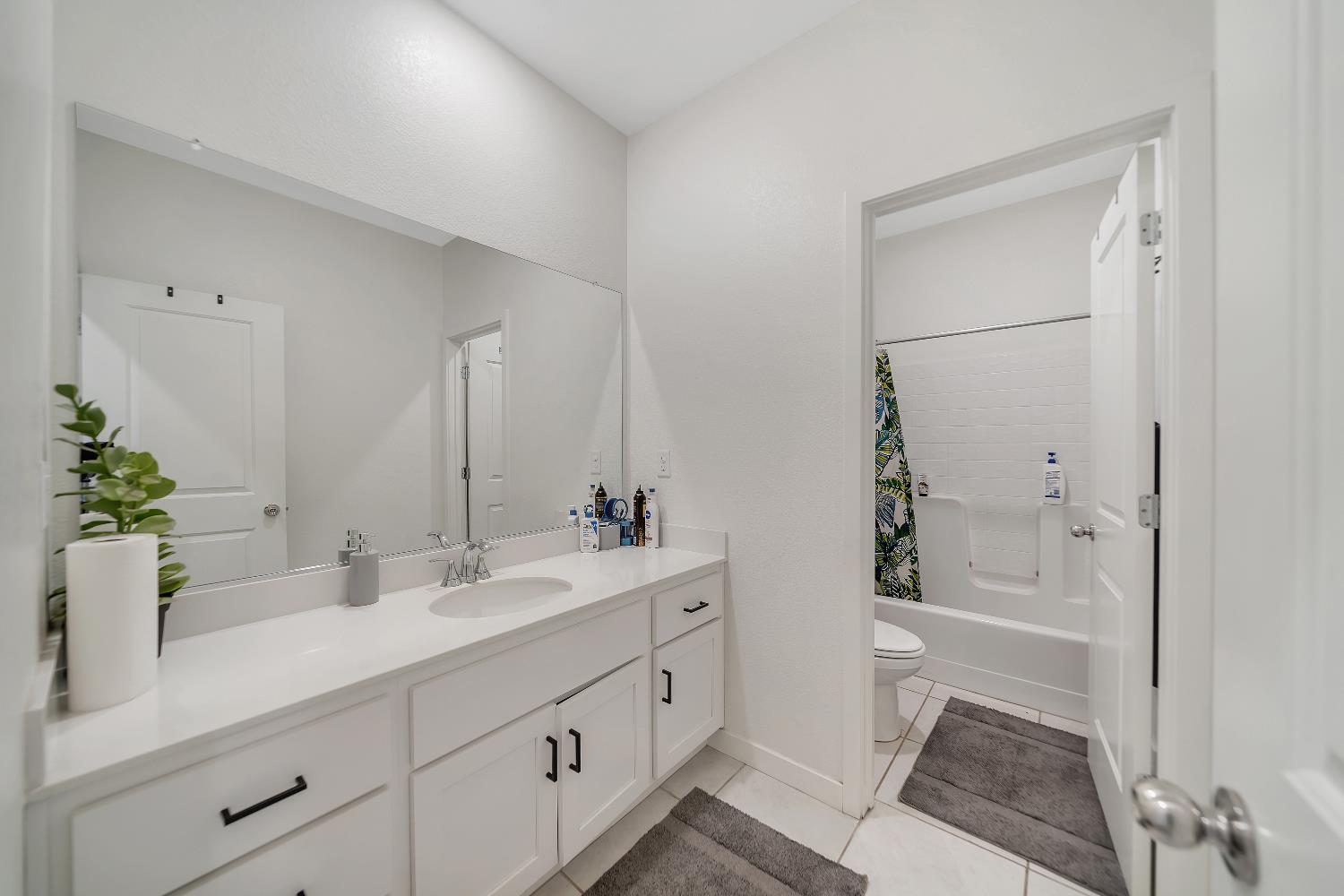 4806 Ariel Street Keyes, CA 95328 - Photo 25 of 42 a bathroom with a double vanity sink a toilet and shower