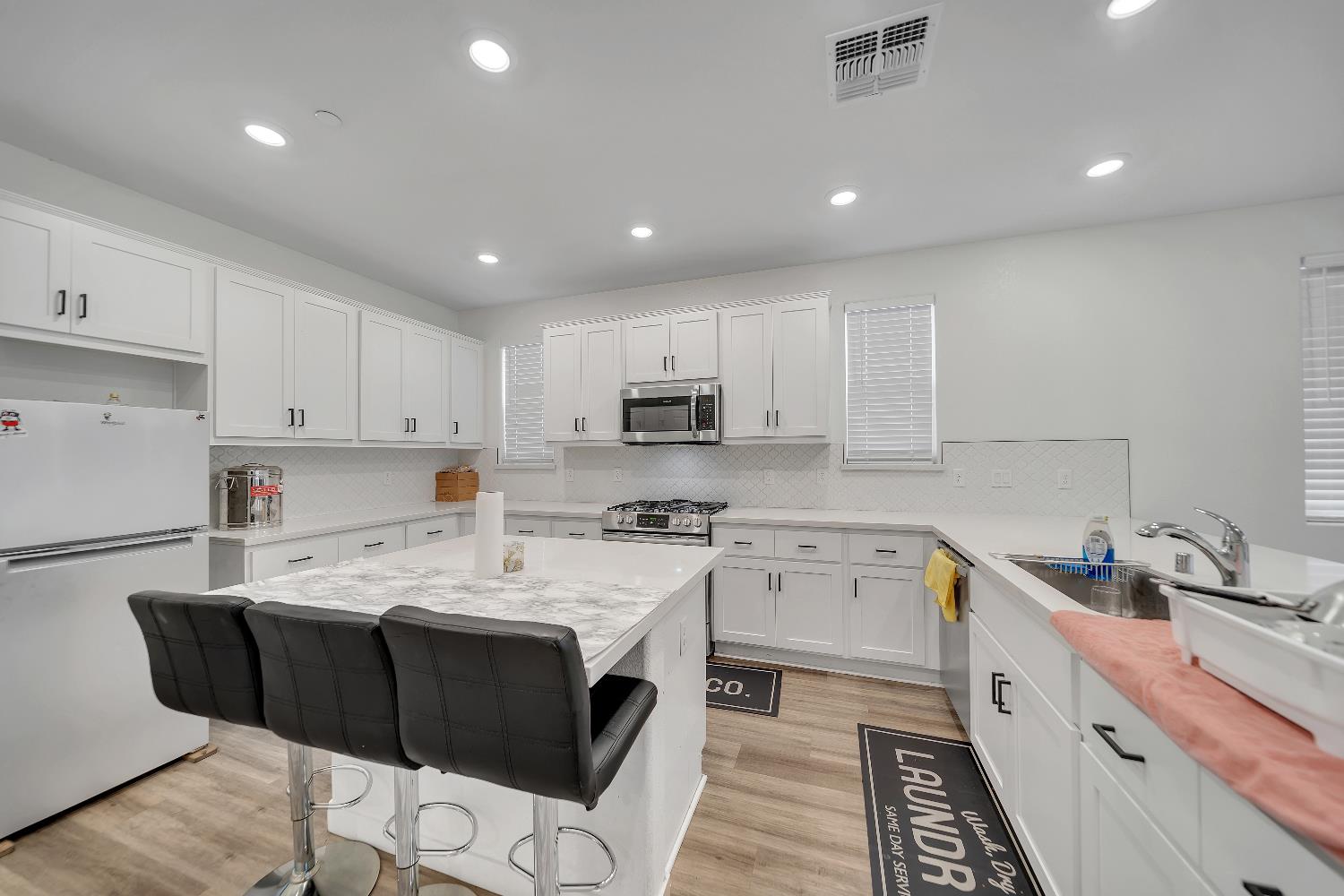 4806 Ariel Street Keyes, CA 95328 - Photo 29 of 42 a kitchen with a sink white cabinets and stainless steel appliances