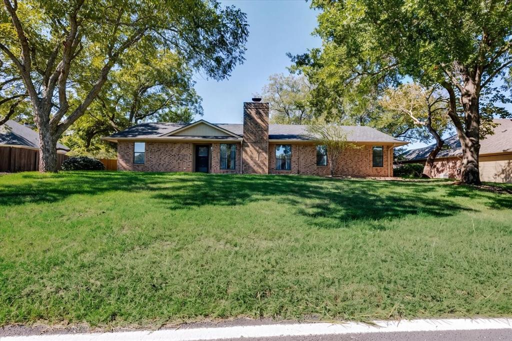 8105 Ravenswood Road Granbury, TX 76049 - Photo 2 of 28 Brick exterior with a prominent chimney, dark-framed windows, and a covered entry