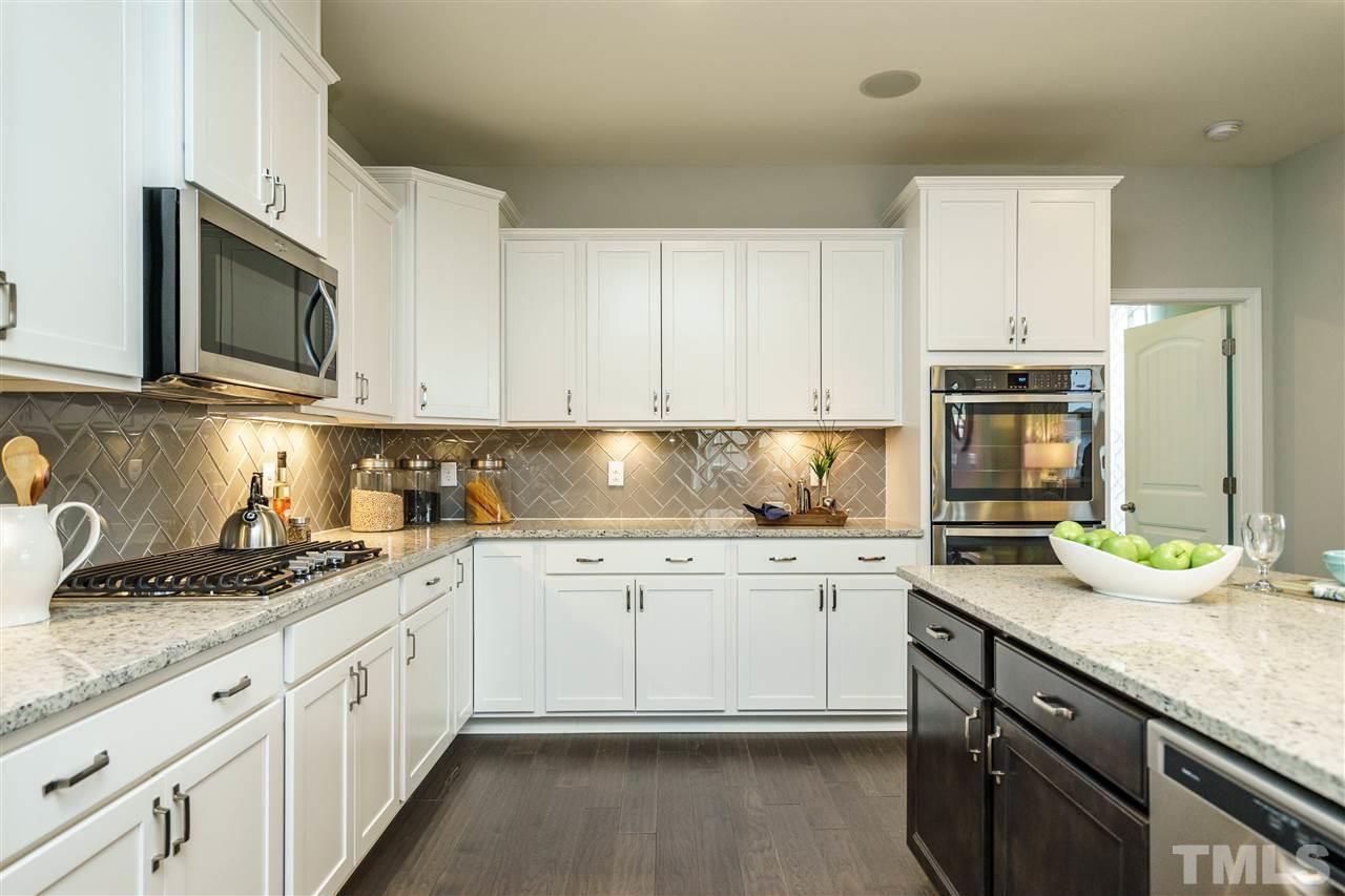 125 Twilight Trail, Unit STONEFIELD Willow Spring, NC 27592 - Photo 11 of 22 a kitchen with granite countertop white cabinets and stainless steel appliances