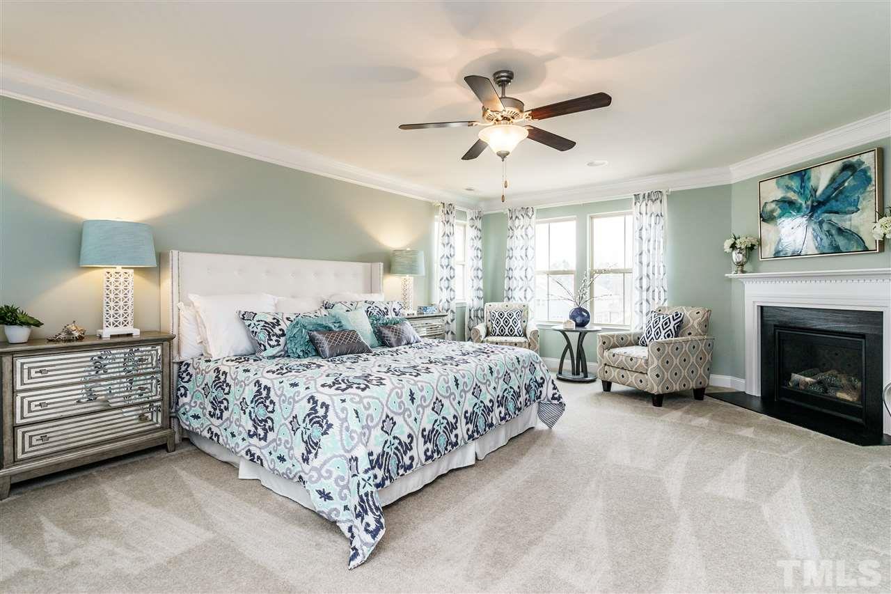 125 Twilight Trail, Unit STONEFIELD Willow Spring, NC 27592 - Photo 18 of 22 a spacious bedroom with a bed a couch and a fireplace