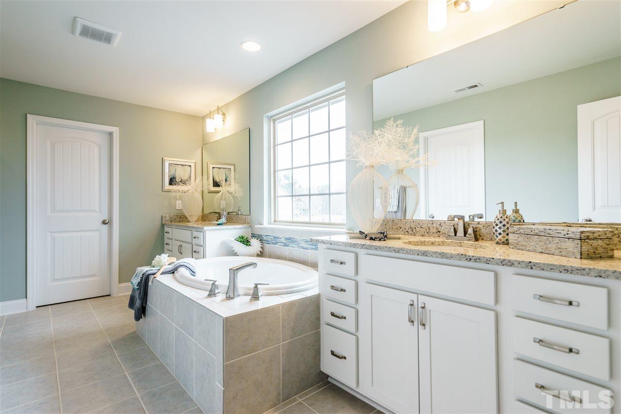 125 Twilight Trail, Unit STONEFIELD Willow Spring, NC 27592 - Photo 20 of 22 a bathroom with a granite countertop tub sink double vanity and mirror