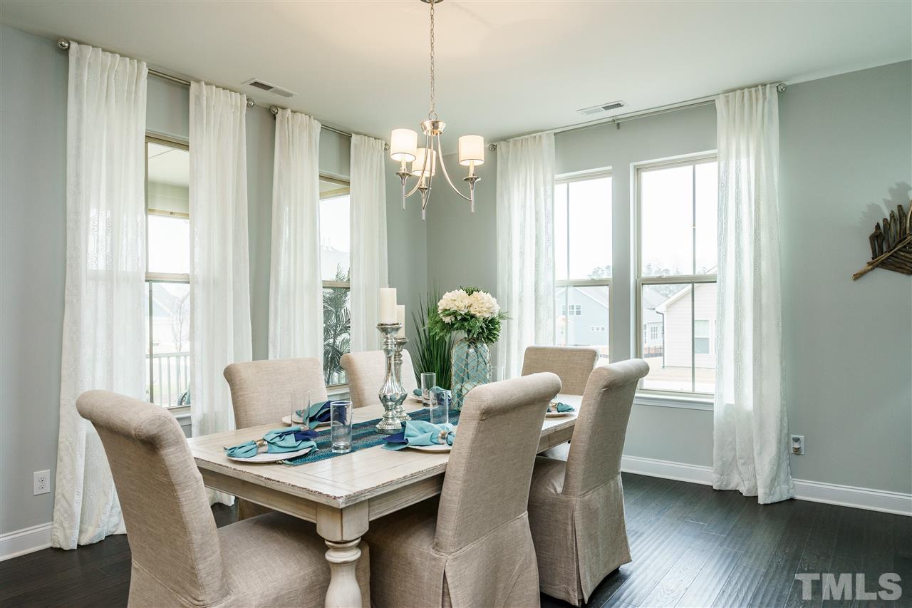 125 Twilight Trail, Unit STONEFIELD Willow Spring, NC 27592 - Photo 6 of 22 a view of a dining room with furniture window and wooden floor