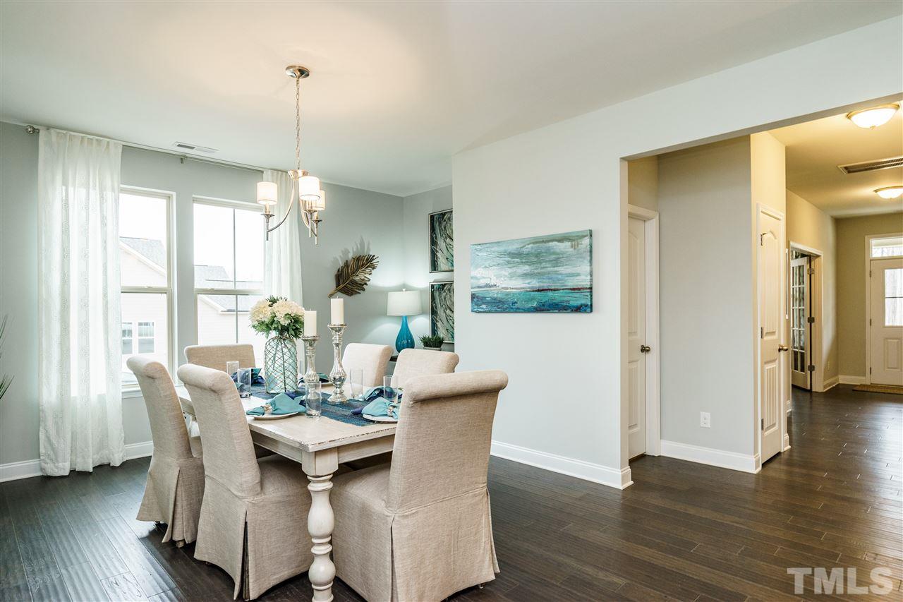 125 Twilight Trail, Unit STONEFIELD Willow Spring, NC 27592 - Photo 8 of 22 a view of a dining room with furniture window and wooden floor