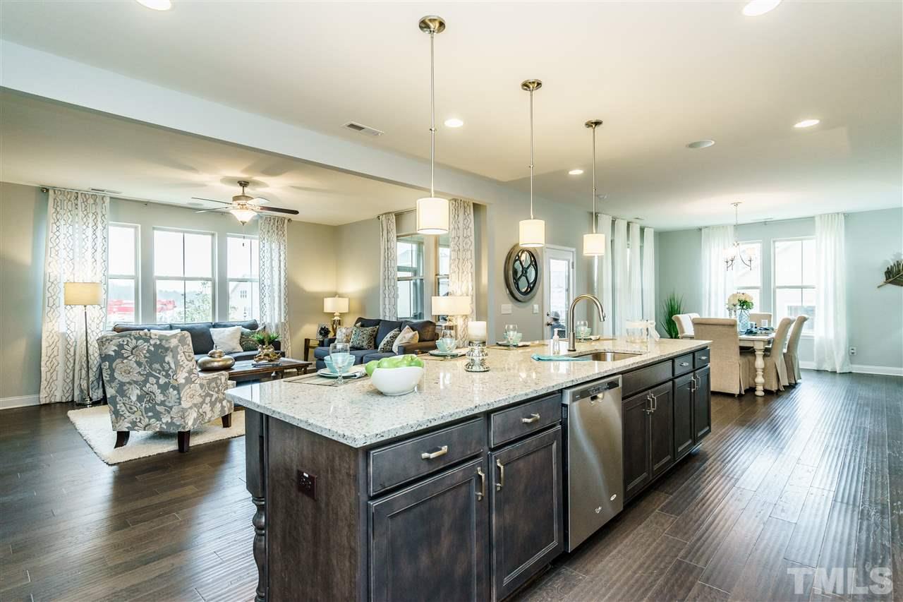 125 Twilight Trail, Unit STONEFIELD Willow Spring, NC 27592 - Photo 10 of 22 a large kitchen with lots of counter space a sink appliances and living room view