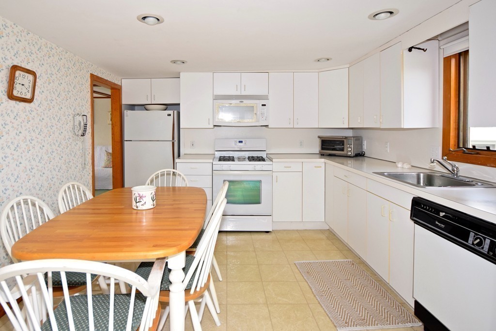 6 Beach Street Wareham, MA 02571 - Photo 8 of 19 a kitchen with stainless steel appliances granite countertop a stove a sink dishwasher and a refrigerator with wooden cabinets