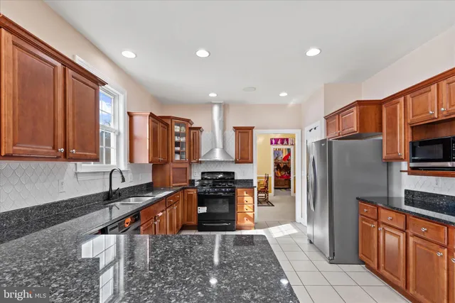 a kitchen with stainless steel appliances granite countertop a refrigerator stove and sink