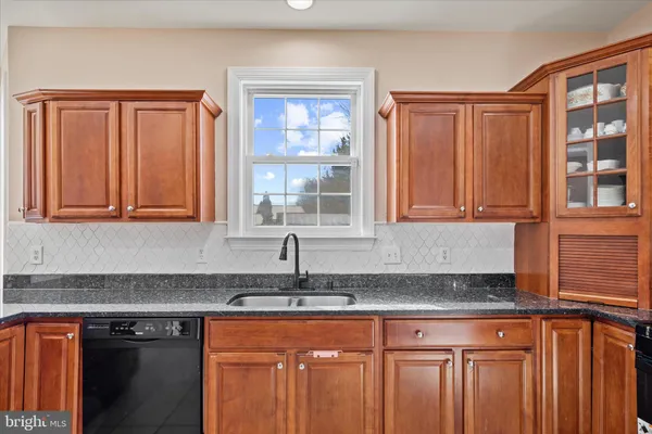 a kitchen with granite countertop cabinets sink and window