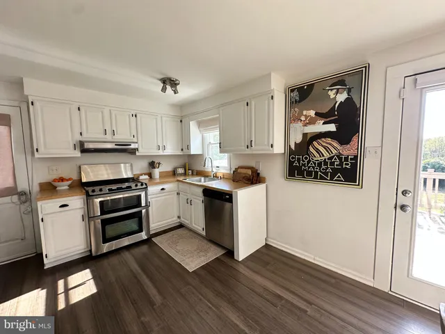 a kitchen with wooden floors and white appliances