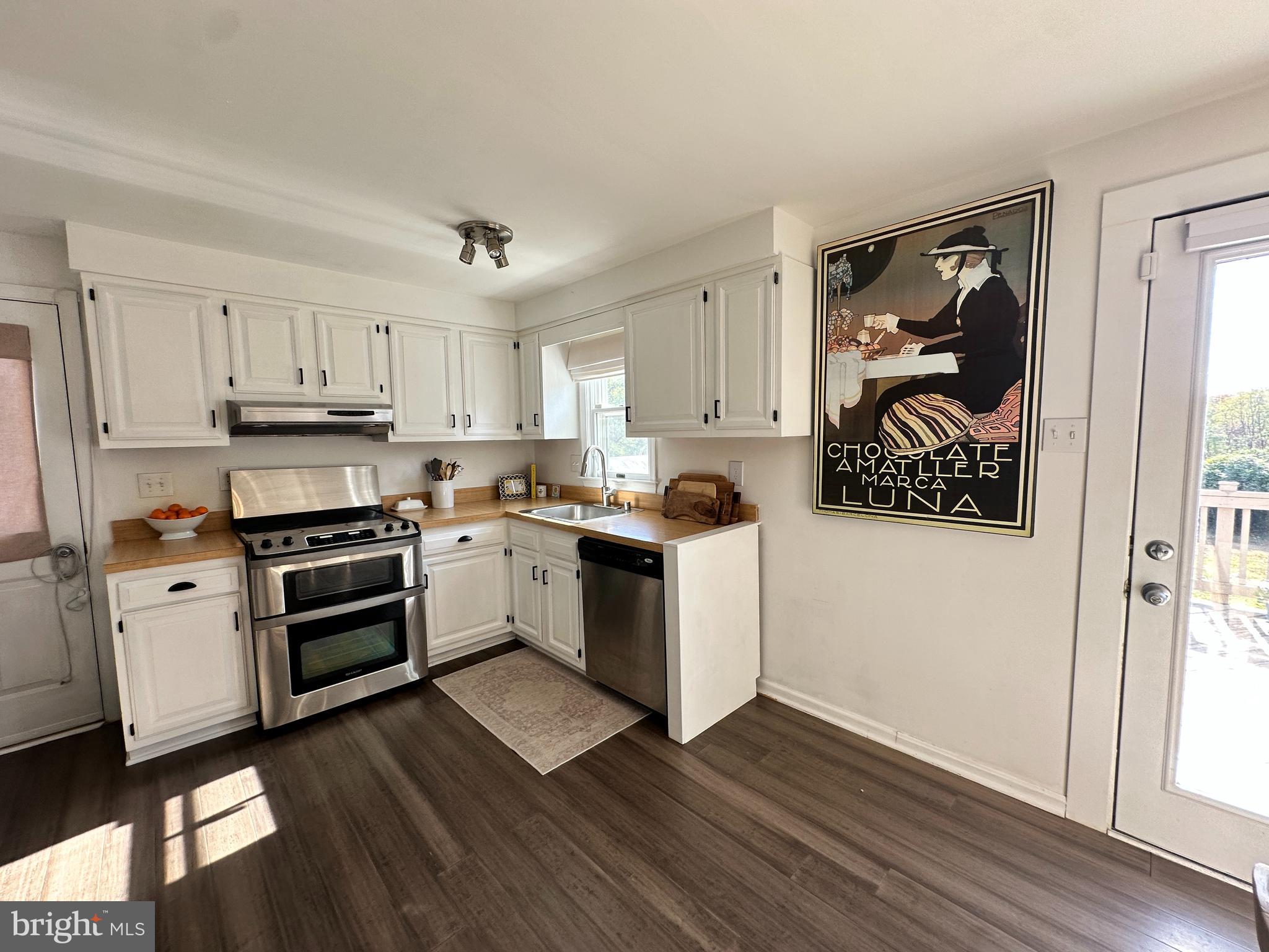 7601 Rudyard Street Falls Church, VA 22043 - Photo 11 of 29 a kitchen with wooden floors and white appliances