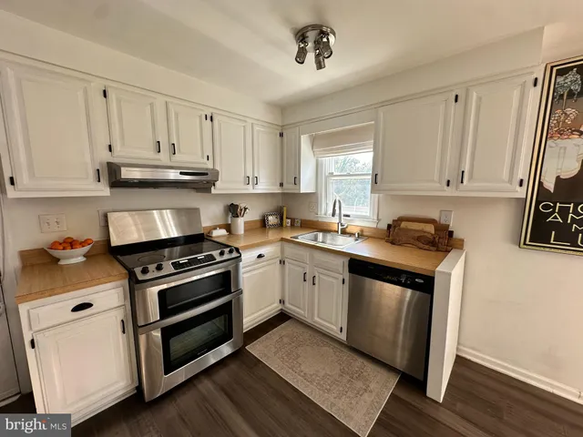 a kitchen with a stove and white cabinets