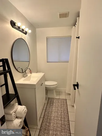 a bathroom with a sink mirror vanity and toilet