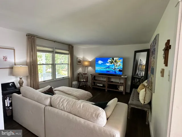 a living room with furniture a window and a flat screen tv