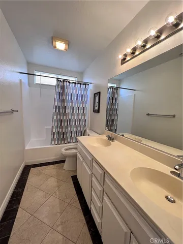 a bathroom with a granite countertop sink a toilet and shower